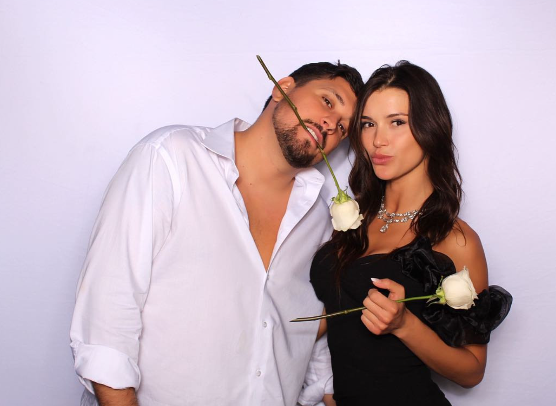 Couple posing with roses at high-end photo booth event