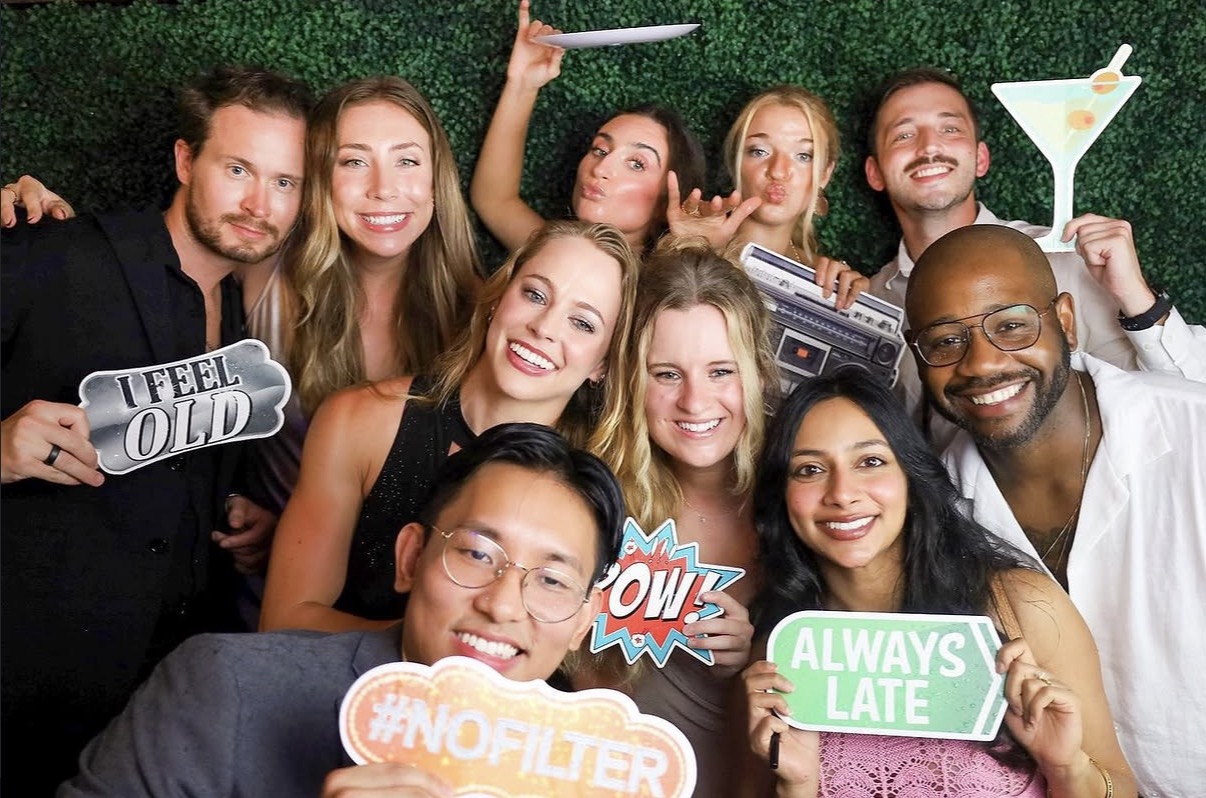 Open Air photo booth at party in Tallahassee with props and greenery wall